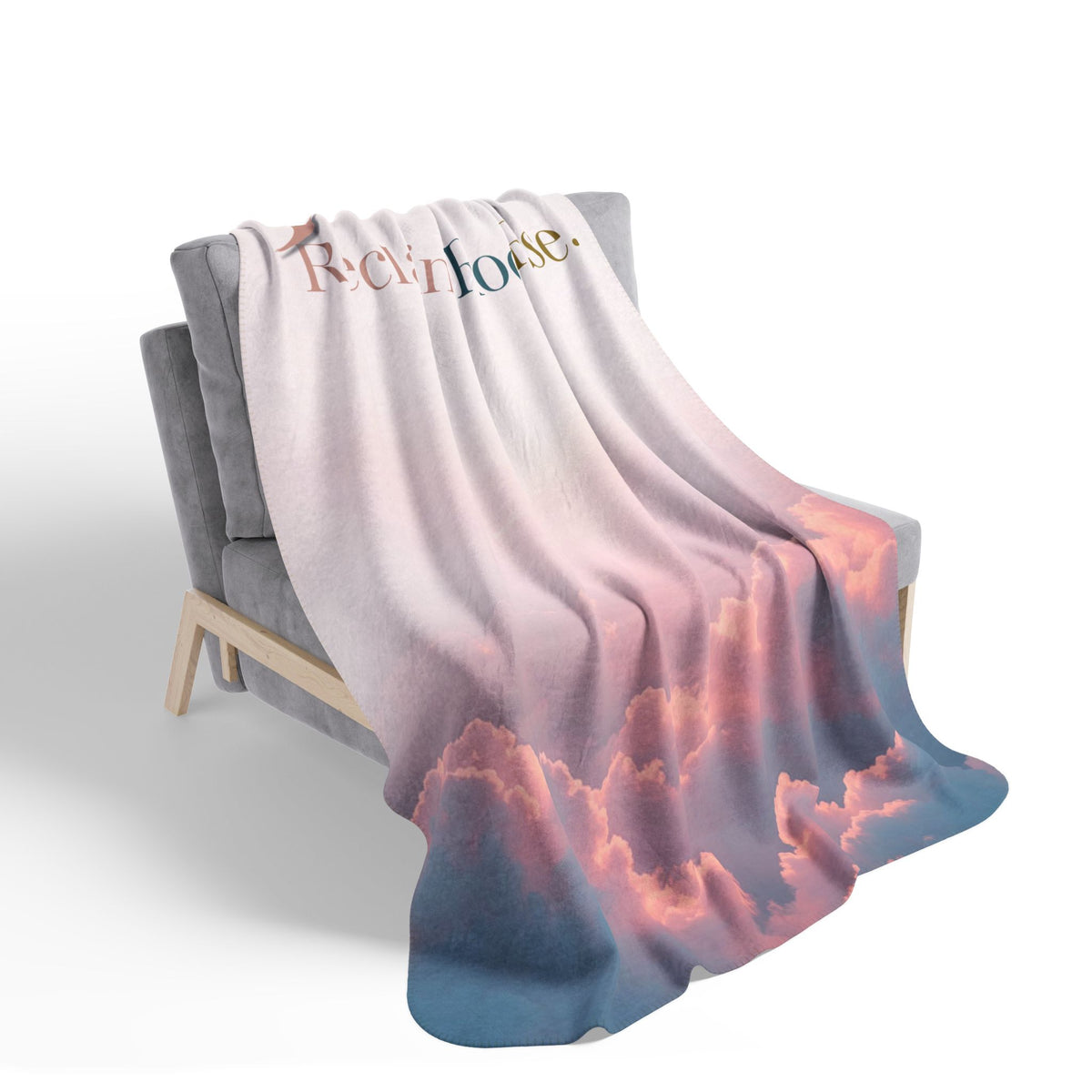 Nurse Sherpa Blanket — blush and coral sunset cloud print draped over a gray armchair